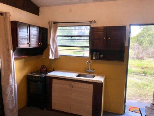a small kitchen with a sink and a window at Cuchilla Alta-La Cabaña Celeste in Cuchilla Alta
