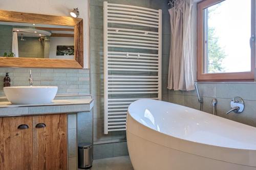 a bathroom with a tub and a sink and a mirror at Ferienwohnung in ruhiger Lage direkt am Wald in Heidenheim an der Brenz