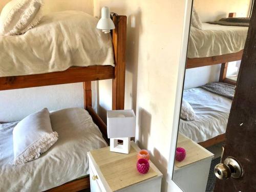 a bedroom with two bunk beds and a mirror at La Cabaña Celeste in Cuchilla Alta