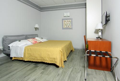 a bedroom with a bed with a yellow blanket at Albergo Al Viale in Trieste