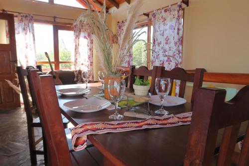 una mesa de comedor con copas de vino. en Cabañas Yanasuy en Merlo