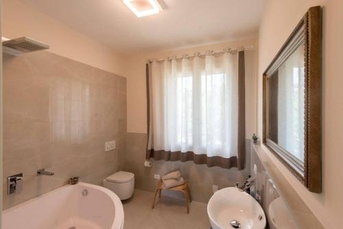 uma casa de banho com uma banheira, um WC e um lavatório. em B&B Ai Filari em Baone