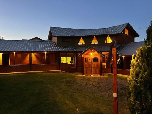 a house with a metal roof and a yard at Ruca Nel in El Calafate