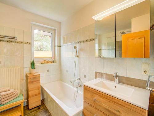 y baño con bañera blanca y lavamanos. en Lovely Apartment in Picturesque Niedernsill with Garden, en Niedernsill