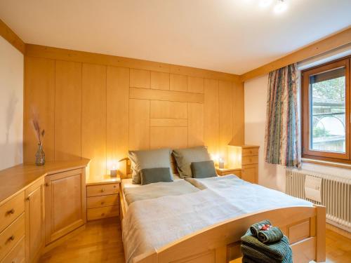 um quarto com uma cama grande e uma janela em Lovely Apartment in Picturesque Niedernsill with Garden em Niedernsill