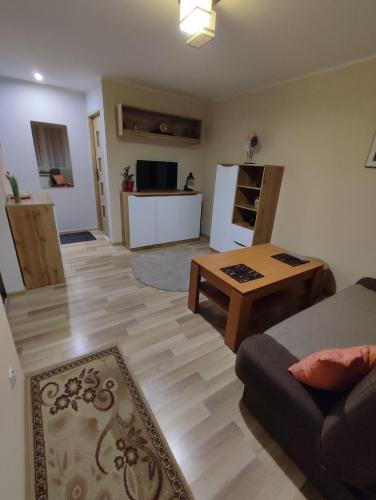 ein Wohnzimmer mit einem Sofa und einem Tisch in der Unterkunft Klimatyczne mieszkanie in Hajnówka