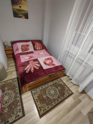 a bedroom with two beds and two rugs on the floor at Klimatyczne mieszkanie in Hajnówka