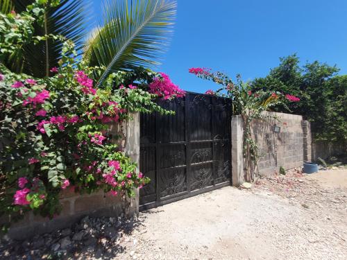 a black gate with pink flowers on a fence at Triton Apartments in Pwani Mchangani