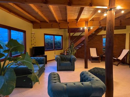 a living room with couches and chairs and a tv at Ruca Nel in El Calafate