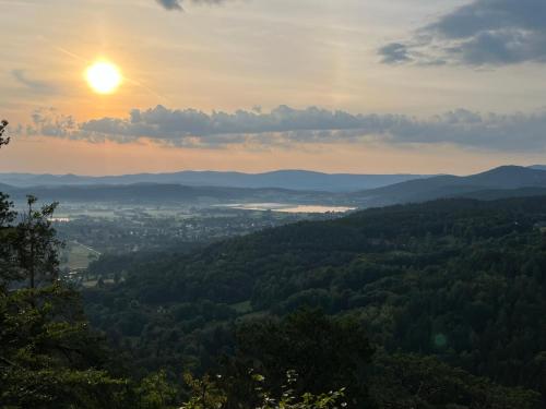 a view of a valley with the sun setting at U Gruszków - domek pod Chojnikiem in Jelenia Góra