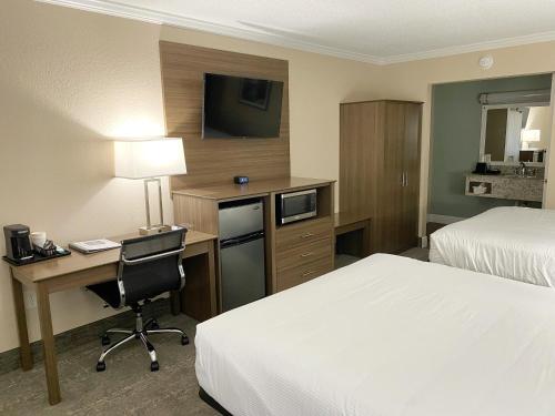 a hotel room with two beds and a desk with a computer at Roadstar Hotel Zephyrhills in Zephyrhills