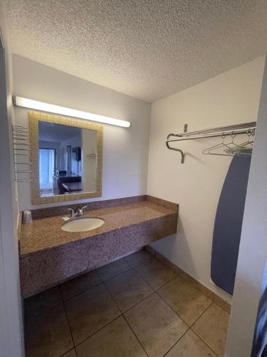 uma casa de banho com um lavatório e um espelho em Ambassador Inn em Kissimmee