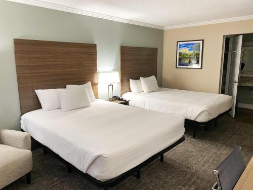 a hotel room with two beds and a couch at Roadstar Hotel Zephyrhills in Zephyrhills
