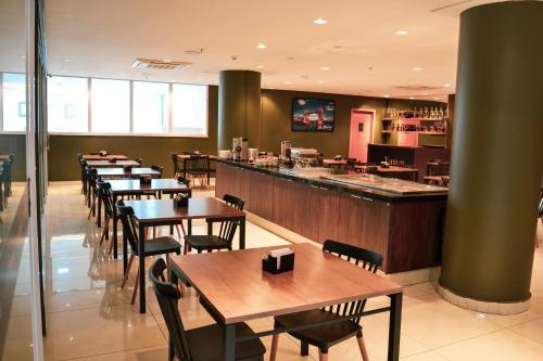 a restaurant with tables and chairs and a bar at Nobile Inn London Anápolis in Anápolis