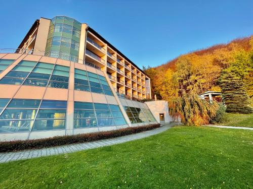 a large building with a grassy yard in front of it at Hotel Belweder in Ustroń