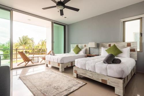 a bedroom with two beds and a balcony at Peaceful & beautiful 3 min walking to the beach in Puerto Morelos