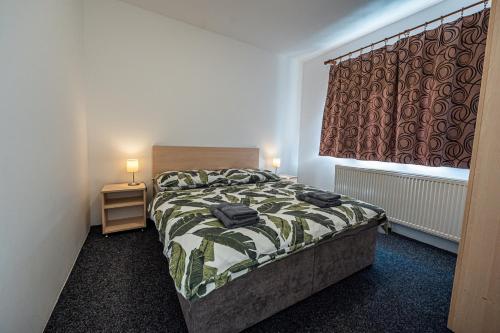 a small bedroom with a bed and a window at XLSuite Apartment Comfort in Piešťany