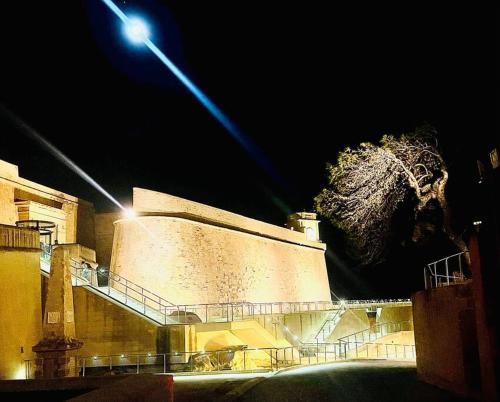 a building with a tree on the side of it at night at 300yr old, self catering, tiny house in Victoria Centre, Gozo in Victoria