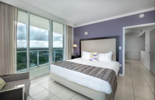 a bedroom with a large bed and a large window at Hotel Arya BW Premier Collection in Miami