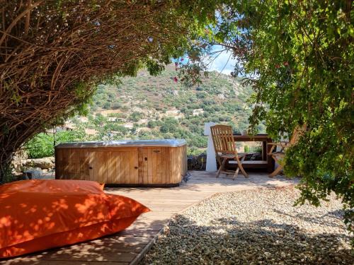 a wooden tub sitting on a patio with a chair at The Cosy Home Corbara by 1722 in Corbara