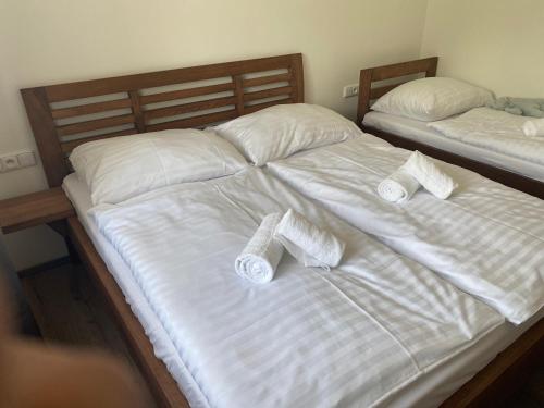 2 Betten mit weißer Bettwäsche und Handtüchern darauf in der Unterkunft Apartmán Katka in Frymburk