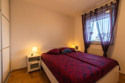 a bedroom with a red bed and a window at Flexible SelfCheckIns 34 - Zagreb - Parking - Big Loggia - New in Zagreb