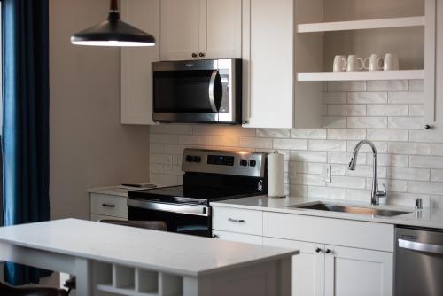 a kitchen with a stove and a sink and a microwave at The Berkman in Rochester
