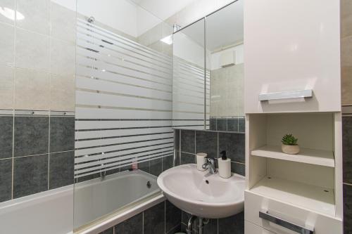 a white bathroom with a sink and a bath tub at Flexible SelfCheckIns 34 - Zagreb - Parking - Big Loggia - New in Zagreb