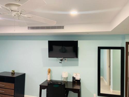 a room with a desk and a ceiling fan at The New View Inn in Tortola Island