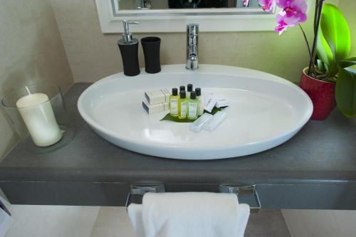 a white sink with bottles and candles on a counter at Demetra Hotel in Rome