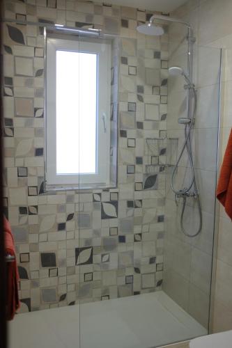 a bathroom with a shower with a window at Sunset and Seaview Apartment -Brand New in Mellieħa