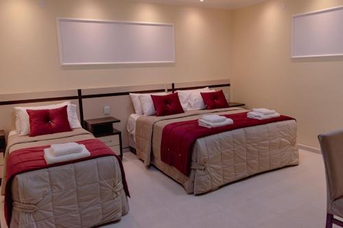 a bedroom with two beds with red pillows at HAUER HOTEL in San Vicente