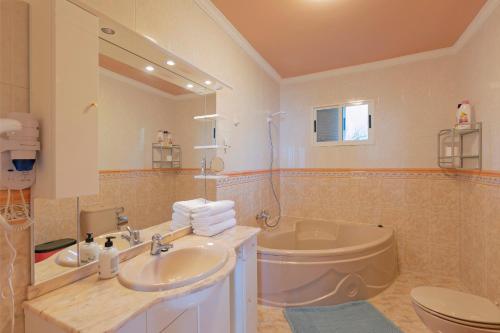 y baño con lavabo, aseo y espejo. en clemente house,private pool, en Arafo