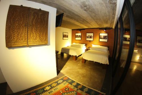 a room with two beds with white sheets at Alfonsina Hotel Boutique in Santa Cruz de la Sierra