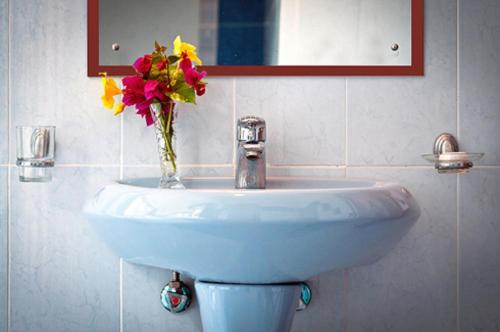 a bathroom sink with a vase of flowers on it at Azul Margarita Beach Resort in Bamburi