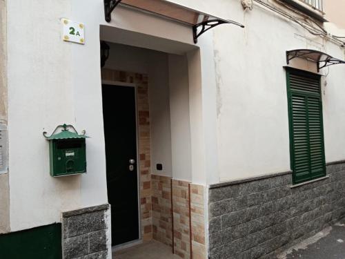 drzwi do budynku z zieloną skrzynką pocztową w obiekcie Etna Bella Home w Katanii