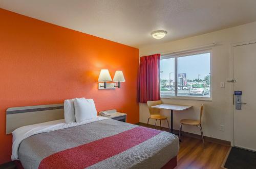 a hotel room with a bed and a table and a window at Motel 6 Cheyenne in Cheyenne