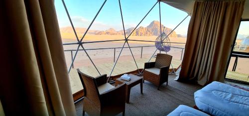 a room with a large window with a view of the desert at Hasan Zawaideh luxury camp 2 in Wadi Rum