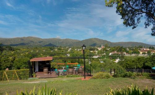 a view of a house with mountains in the background at Castelar - Hotel & Apart in Huerta Grande