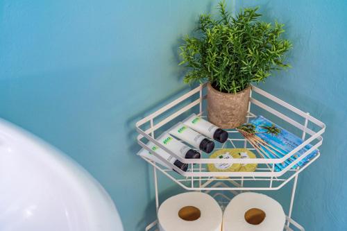 a white rack with toilet paper and a plant at The Estate at Mt Dora in Mount Dora