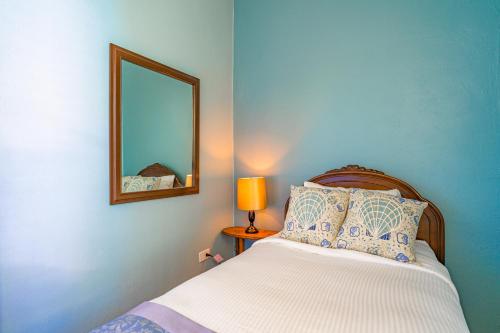 a bedroom with a bed with a mirror and a lamp at The Estate at Mt Dora in Mount Dora
