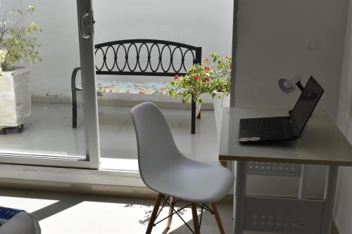 a white chair sitting next to a desk with a laptop at Color House Santa Marta in Santa Marta