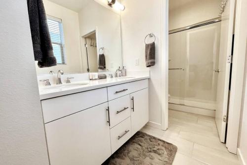 a white bathroom with two sinks and a mirror at Mills SACRAMENTO TOWNHOUSE NEAR DOWNTOWN in Sacramento
