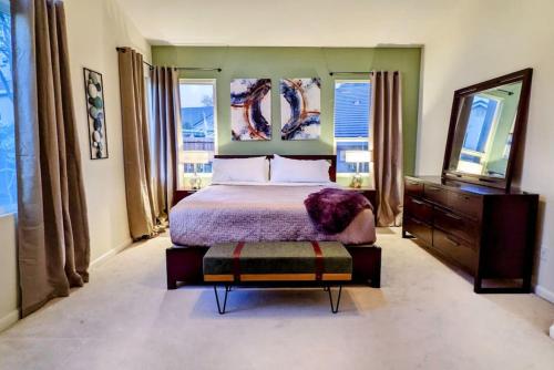 a bedroom with a bed and a dresser and windows at King Bed Quiet Home on Cul-de-Sac Hiking Trails in Roseville