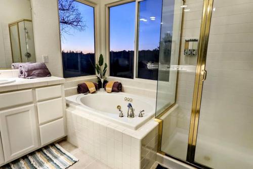 a bathroom with a tub and a shower and a sink at King Bed Quiet Home on Cul-de-Sac Hiking Trails in Roseville