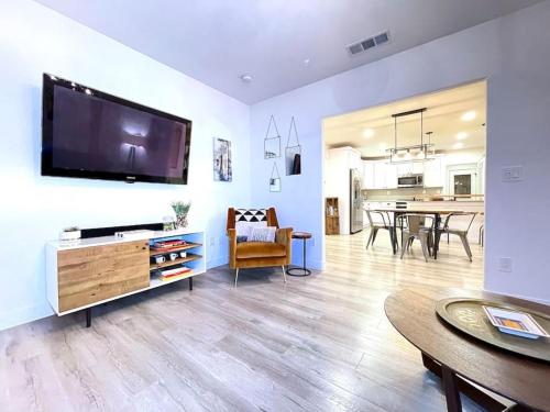 a living room with a large flat screen tv on a wall at King Bed-Private Yard-Driveway Parking in Sacramento