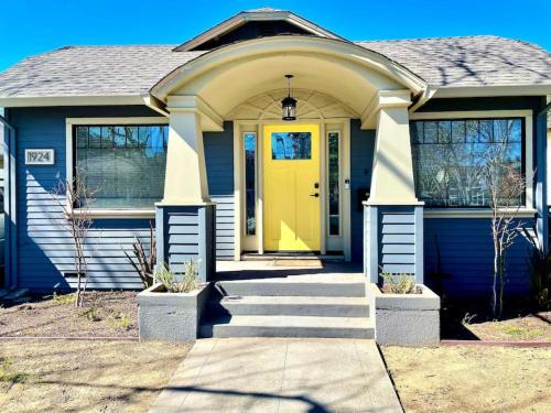 a blue house with a yellow door at King Bed-Private Yard-Driveway Parking in Sacramento