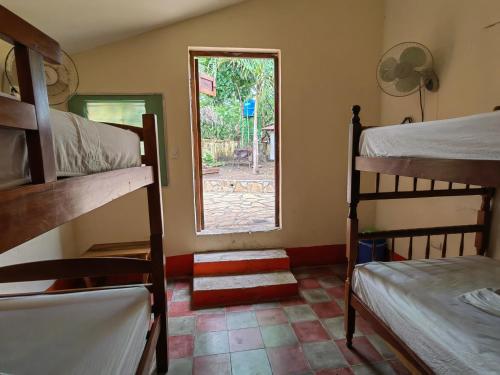 a room with two bunk beds and a window at Hotel Restaurante Spa La Barca de Oro in Las Peñitas