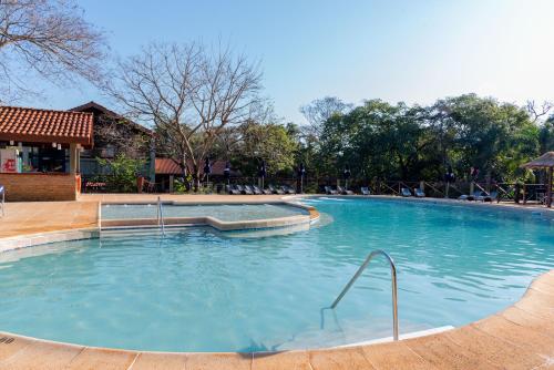 uma grande piscina com água azul em Village Cataratas em Porto Iguaçu