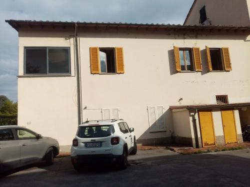 ein weißes Auto, das vor einem Haus parkt in der Unterkunft Appartamento HAPPY DAYS con 1 posto auto privato in Lucca